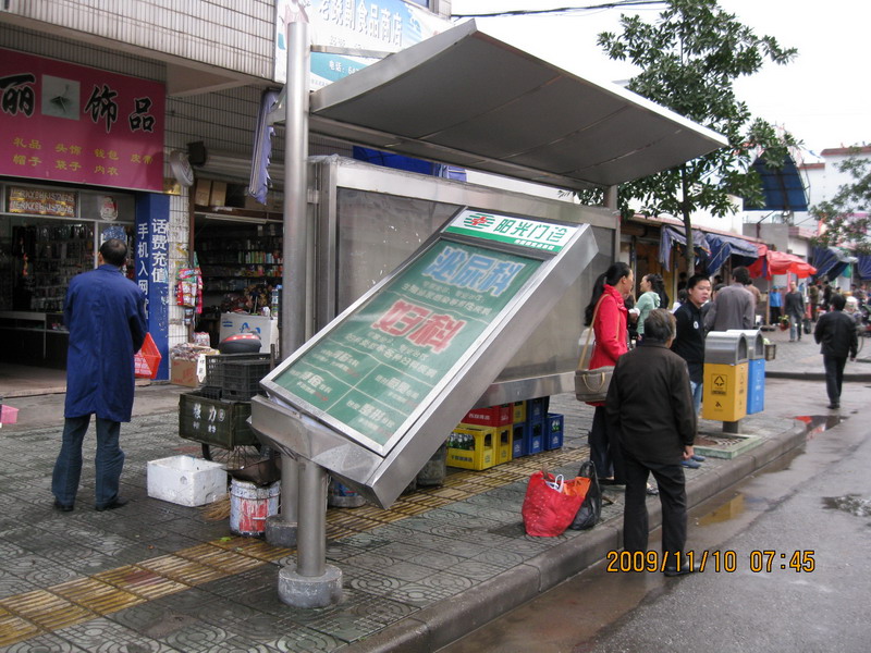 公交站台路牌被狂风刮倒的照片